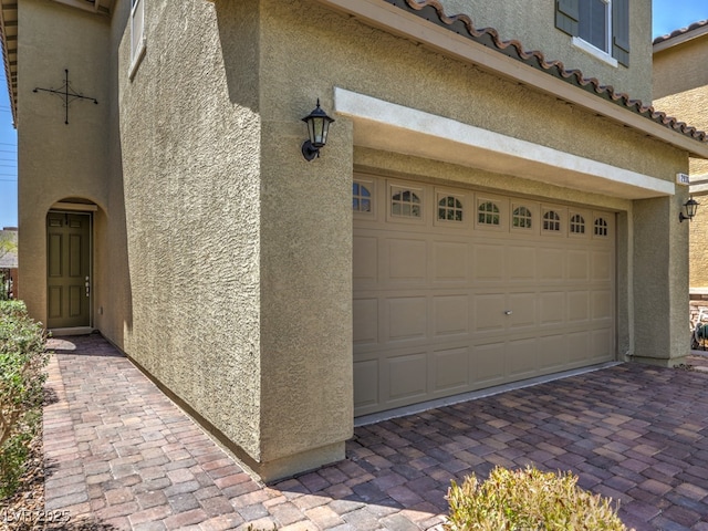 garage with decorative driveway