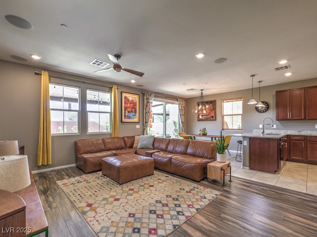 living area featuring visible vents, baseboards, ceiling fan, recessed lighting, and light wood finished floors