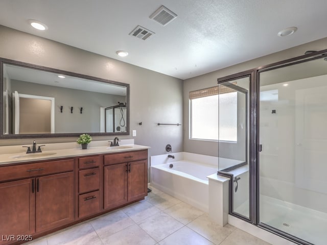 bathroom with a sink, a garden tub, and visible vents