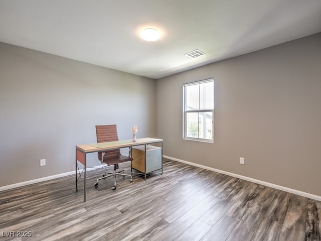 office space featuring baseboards, wood finished floors, and visible vents