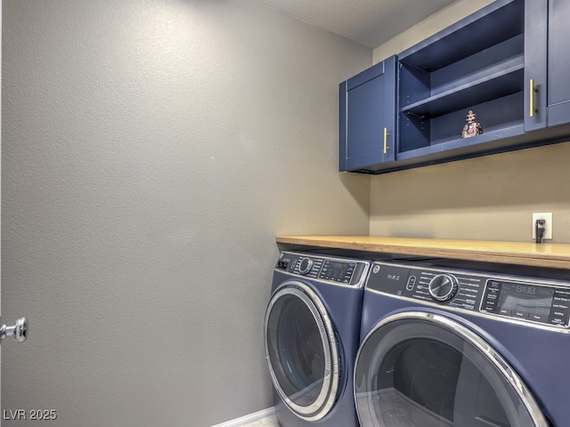 laundry area featuring separate washer and dryer, cabinet space, and baseboards