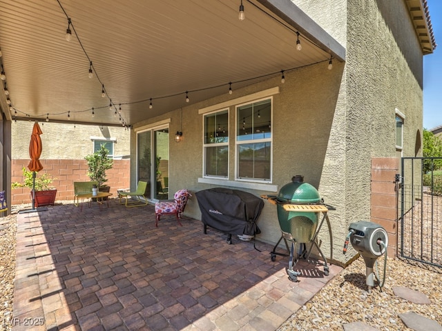 view of patio / terrace featuring area for grilling, fence, and a gate
