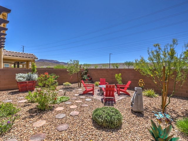 view of yard featuring a fenced backyard, a patio, and a mountain view