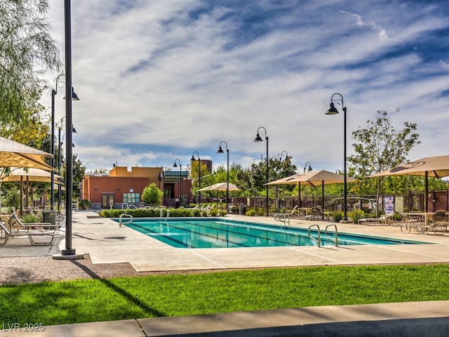 community pool featuring fence and a patio area