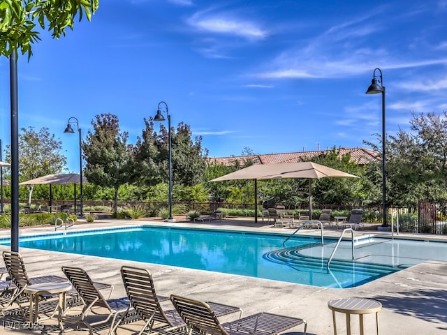 community pool with a patio and fence