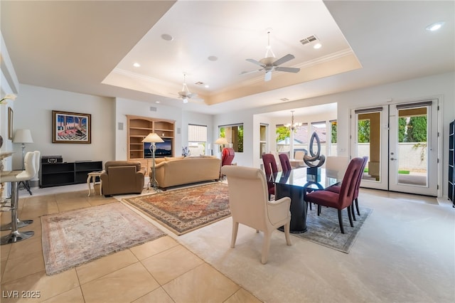 dining space with a raised ceiling, ceiling fan with notable chandelier, recessed lighting, and light tile patterned flooring
