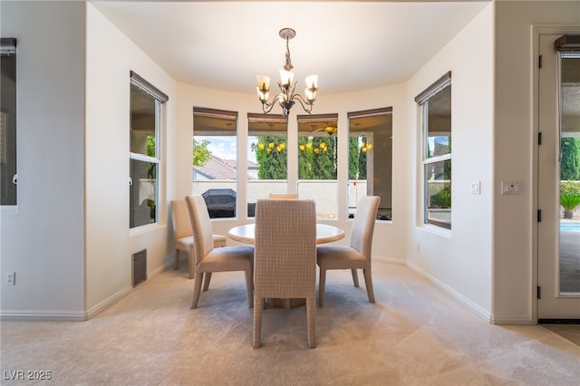 dining space featuring light colored carpet, baseboards, an inviting chandelier, and a healthy amount of sunlight