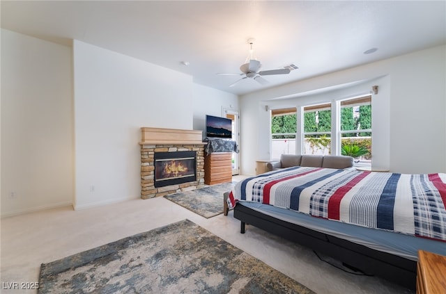 carpeted bedroom featuring baseboards, a fireplace, a ceiling fan, and visible vents