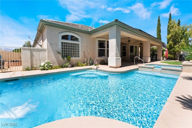 view of pool with fence, a ceiling fan, a pool with connected hot tub, and a patio area
