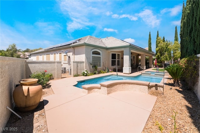 view of swimming pool featuring a pool with connected hot tub, ceiling fan, a fenced backyard, a gate, and a patio area
