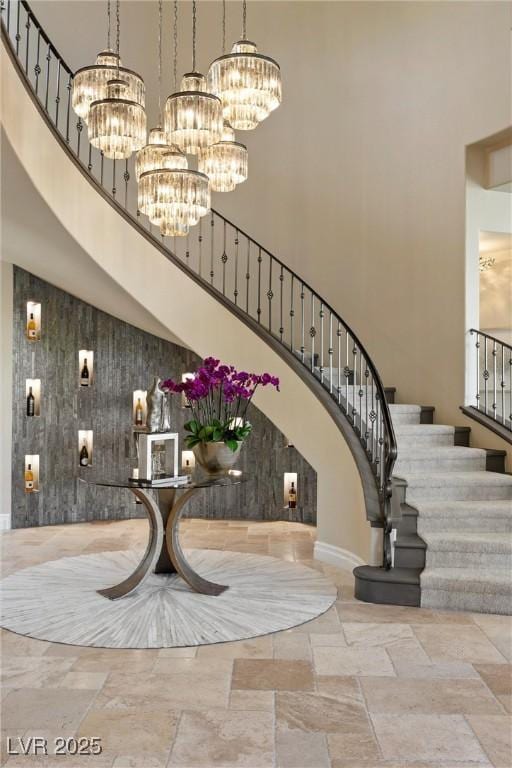 17 Grand Corniche Dr, Henderson, NV 89011 - foyer entrance with an inviting chandelier, stone tile flooring, stairway, and a towering ceiling