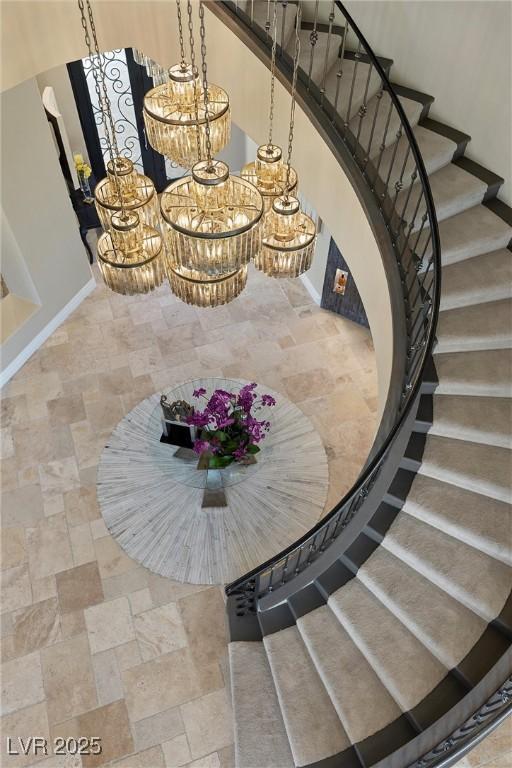 17 Grand Corniche Dr, Henderson, NV 89011 - dining space with a high ceiling, an inviting chandelier, stone finish floor, stairs, and baseboards