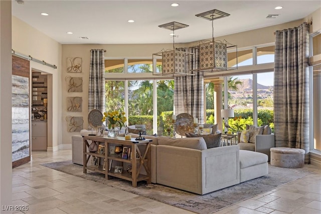 17 Grand Corniche Dr, Henderson, NV 89011 - living room with visible vents, stone tile flooring, baseboards, recessed lighting, and a barn door