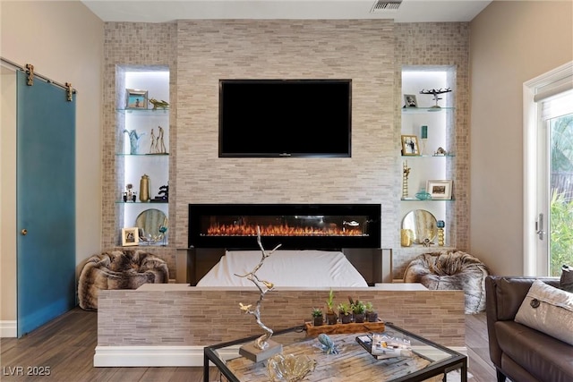 17 Grand Corniche Dr, Henderson, NV 89011 - living area featuring a glass covered fireplace, baseboards, wood finished floors, and visible vents