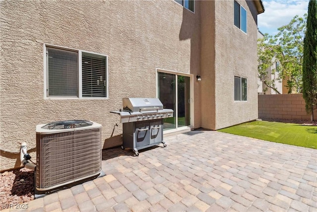 view of patio / terrace featuring central air condition unit, fence, and a grill