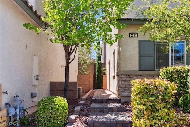 property entrance with stucco siding and stone siding