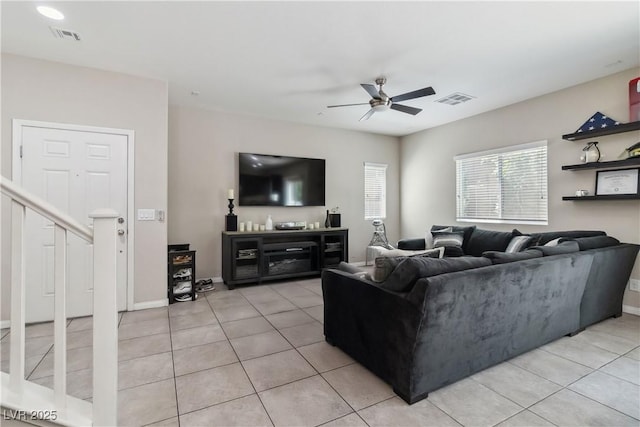 living room with ceiling fan, light tile patterned flooring, stairs, and baseboards