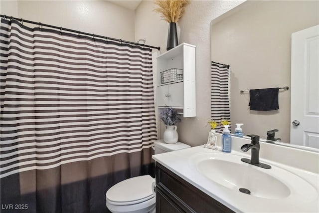 bathroom featuring toilet, vanity, and curtained shower