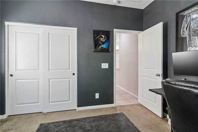 office featuring light colored carpet, baseboards, and light tile patterned floors