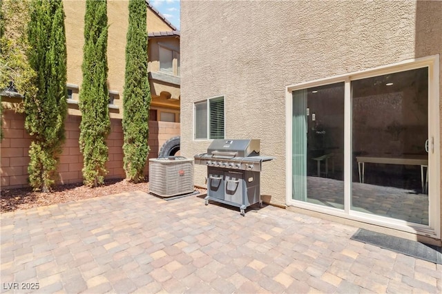 view of patio featuring a grill and fence