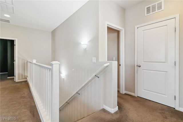 hallway featuring an upstairs landing, carpet, and baseboards