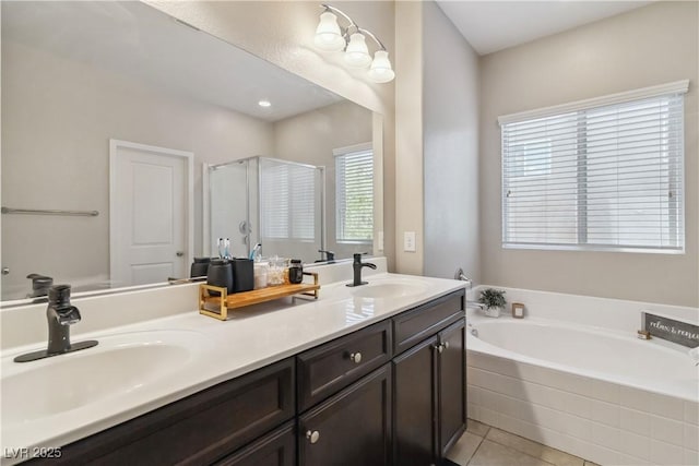 bathroom featuring a bath, a stall shower, double vanity, and tile patterned floors