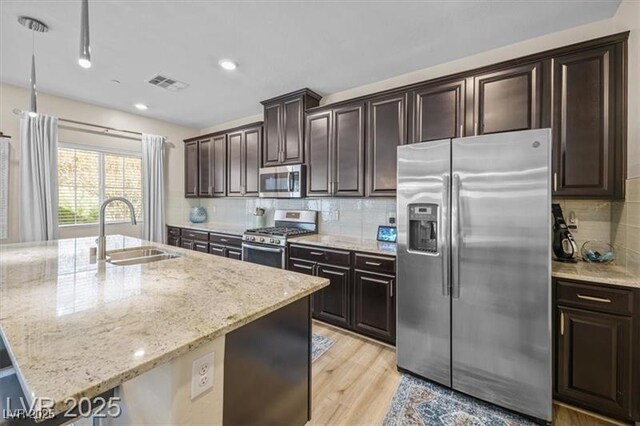 4465 Shimmering Skies St Unit 1177, North Las Vegas, NV 89031 - kitchen featuring decorative backsplash, visible vents, light stone countertops, a sink, and stainless steel appliances
