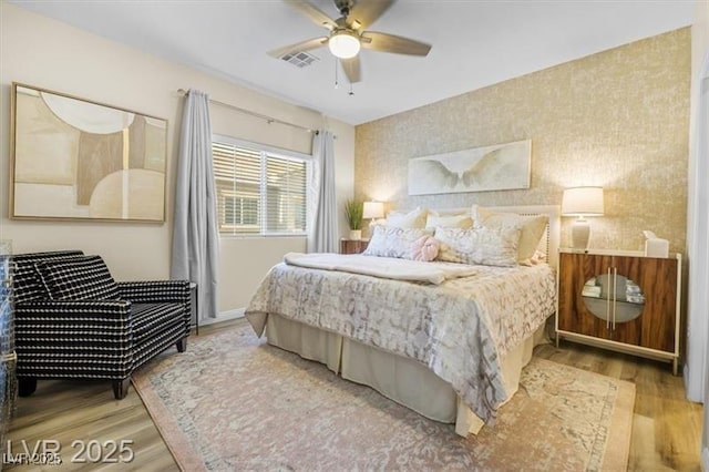 4465 Shimmering Skies St Unit 1177, North Las Vegas, NV 89031 - bedroom with a ceiling fan, visible vents, wood finished floors, baseboards, and wallpapered walls