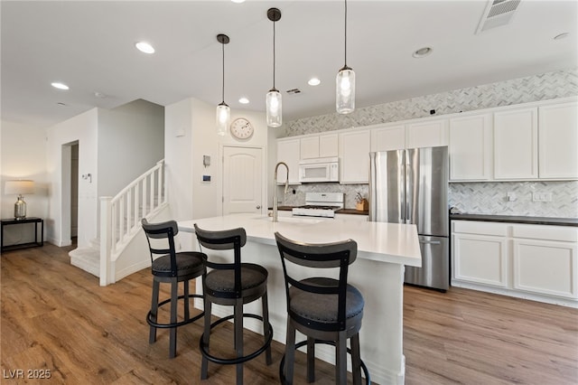 2606 Marvel Astoria St, Henderson, NV 89044 - kitchen featuring backsplash, a center island with sink, a sink, recessed lighting, and white appliances