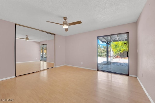 empty room with a healthy amount of sunlight, ceiling fan, and light wood-style floors