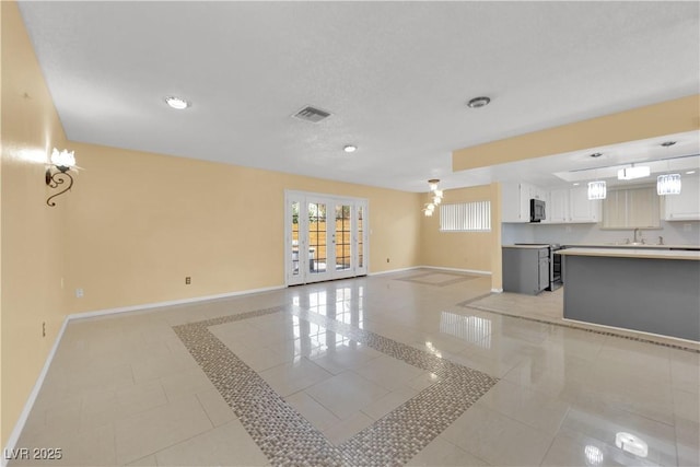 unfurnished living room featuring baseboards, recessed lighting, visible vents, and a sink