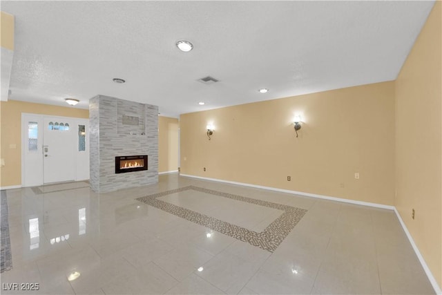 unfurnished living room featuring visible vents, recessed lighting, tile patterned flooring, baseboards, and a tiled fireplace