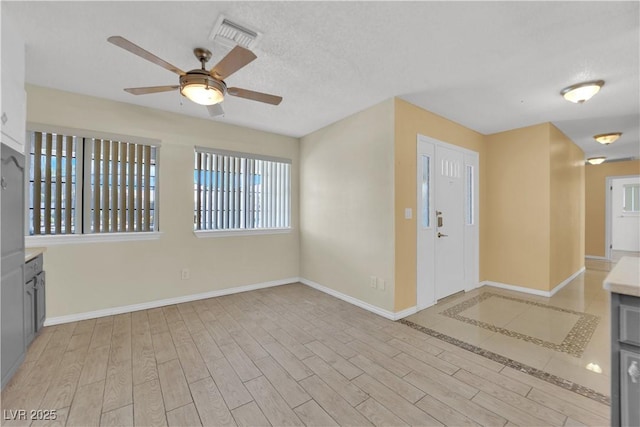 foyer with ceiling fan, baseboards, plenty of natural light, and wood finished floors