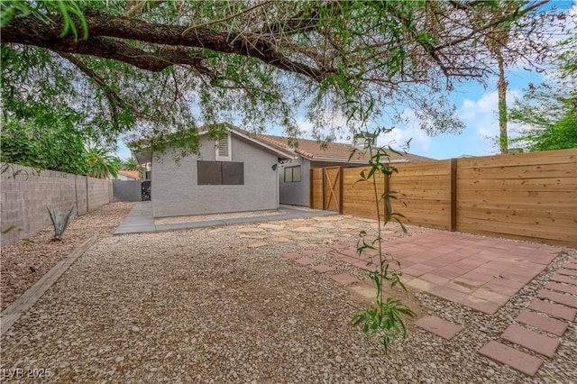 back of house with a patio area, stucco siding, and a fenced backyard
