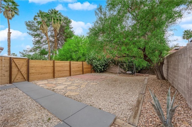 view of yard featuring a fenced backyard and a gate