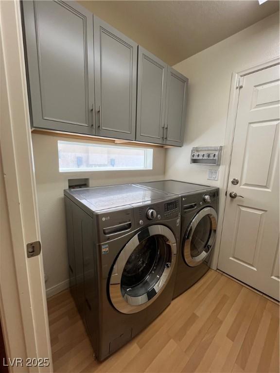 10974 Fintry Hills St, Las Vegas, NV 89141 - washroom with light wood-type flooring, cabinet space, and washer and dryer