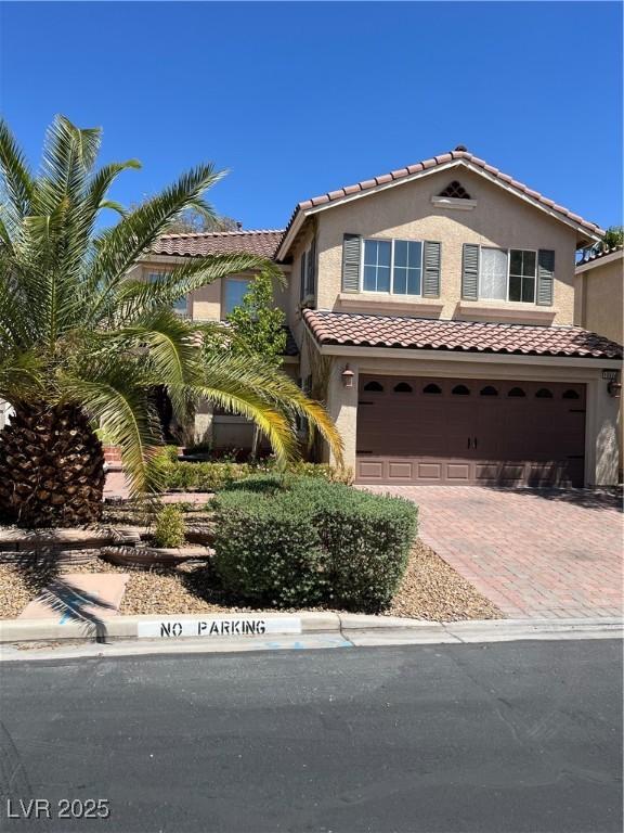 10974 Fintry Hills St, Las Vegas, NV 89141 - mediterranean / spanish home with decorative driveway, a garage, stucco siding, and a tiled roof