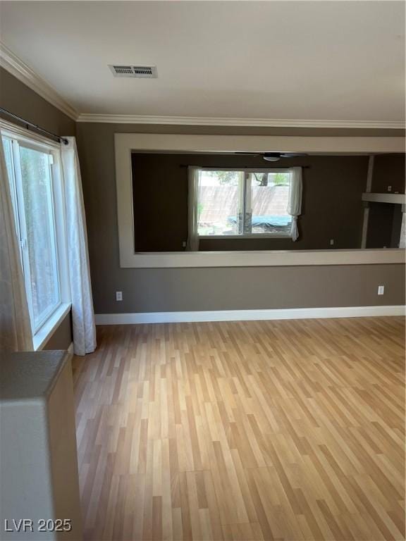 10974 Fintry Hills St, Las Vegas, NV 89141 - empty room featuring plenty of natural light, ornamental molding, light wood finished floors, and visible vents