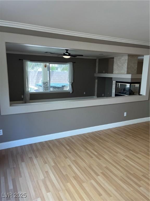 10974 Fintry Hills St, Las Vegas, NV 89141 - unfurnished living room featuring crown molding, baseboards, wood finished floors, and a fireplace