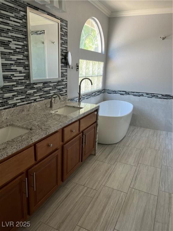 10974 Fintry Hills St, Las Vegas, NV 89141 - full bathroom featuring double vanity, crown molding, tile walls, a freestanding tub, and a sink