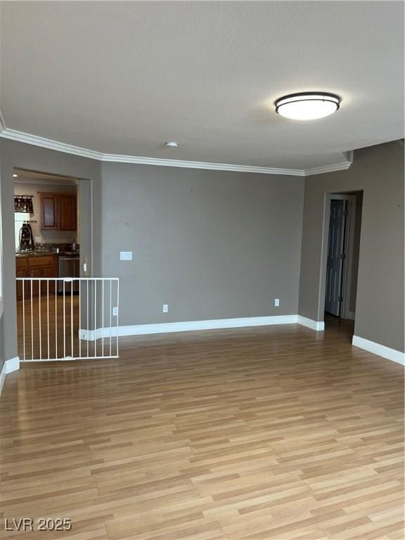 10974 Fintry Hills St, Las Vegas, NV 89141 - spare room featuring baseboards, light wood-style flooring, and crown molding