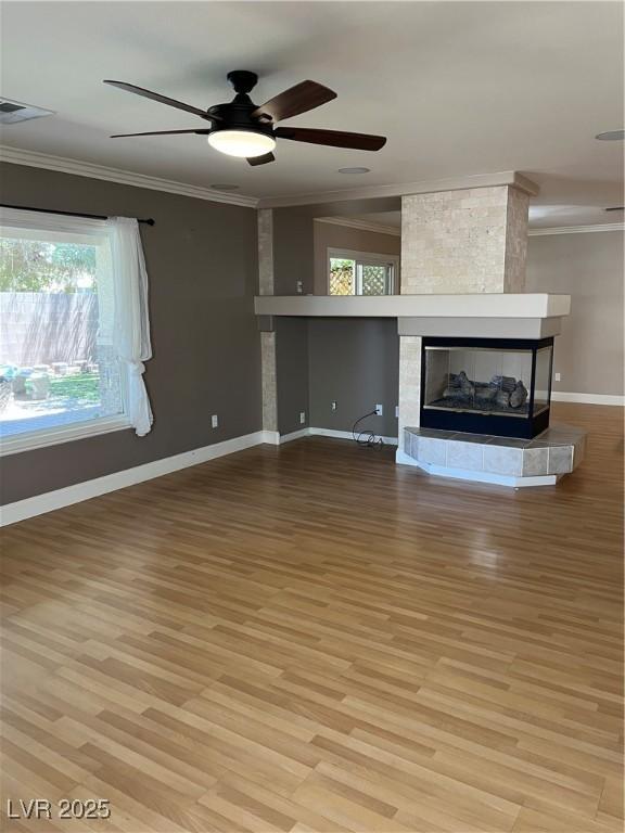 10974 Fintry Hills St, Las Vegas, NV 89141 - unfurnished living room featuring baseboards, ornamental molding, and a wealth of natural light