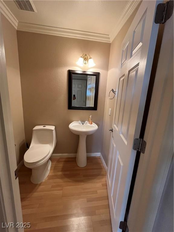 10974 Fintry Hills St, Las Vegas, NV 89141 - half bath featuring visible vents, ornamental molding, wood finished floors, toilet, and baseboards