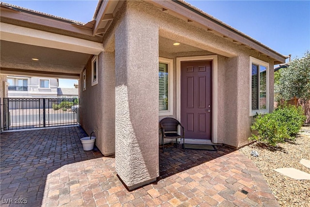 entrance to property featuring stucco siding and a patio area