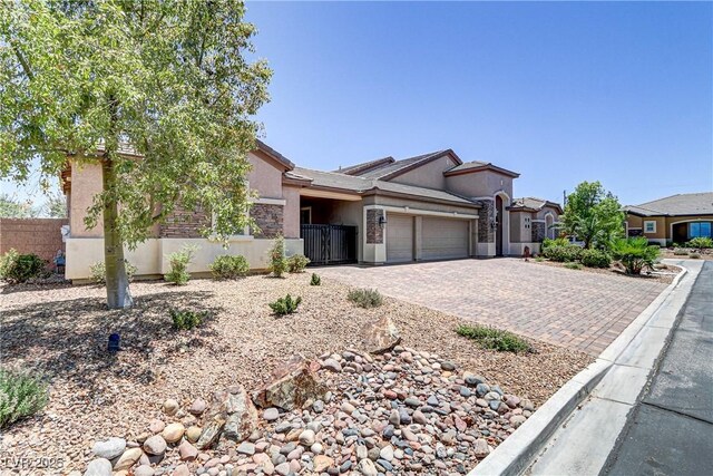 view of front of home with a garage, fence, stucco siding, and decorative driveway
