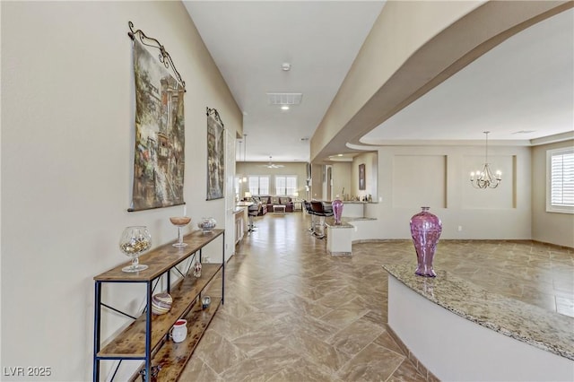 corridor with recessed lighting, a notable chandelier, and visible vents