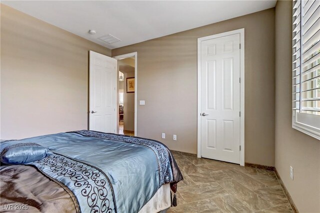 bedroom featuring baseboards and stone finish flooring