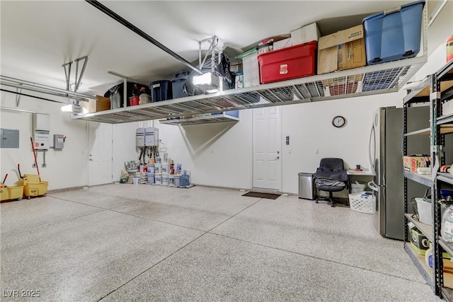 garage featuring freestanding refrigerator, a garage door opener, and electric panel