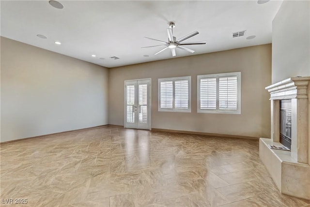 unfurnished living room with a ceiling fan, visible vents, baseboards, recessed lighting, and a premium fireplace