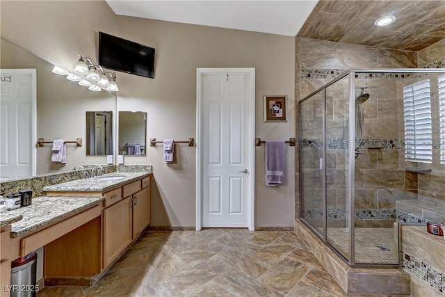 bathroom with vanity, baseboards, and a stall shower